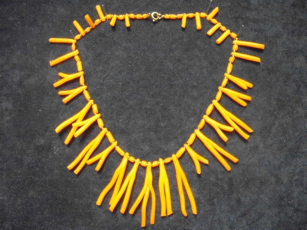 Na sliki je oranžna ogrlica